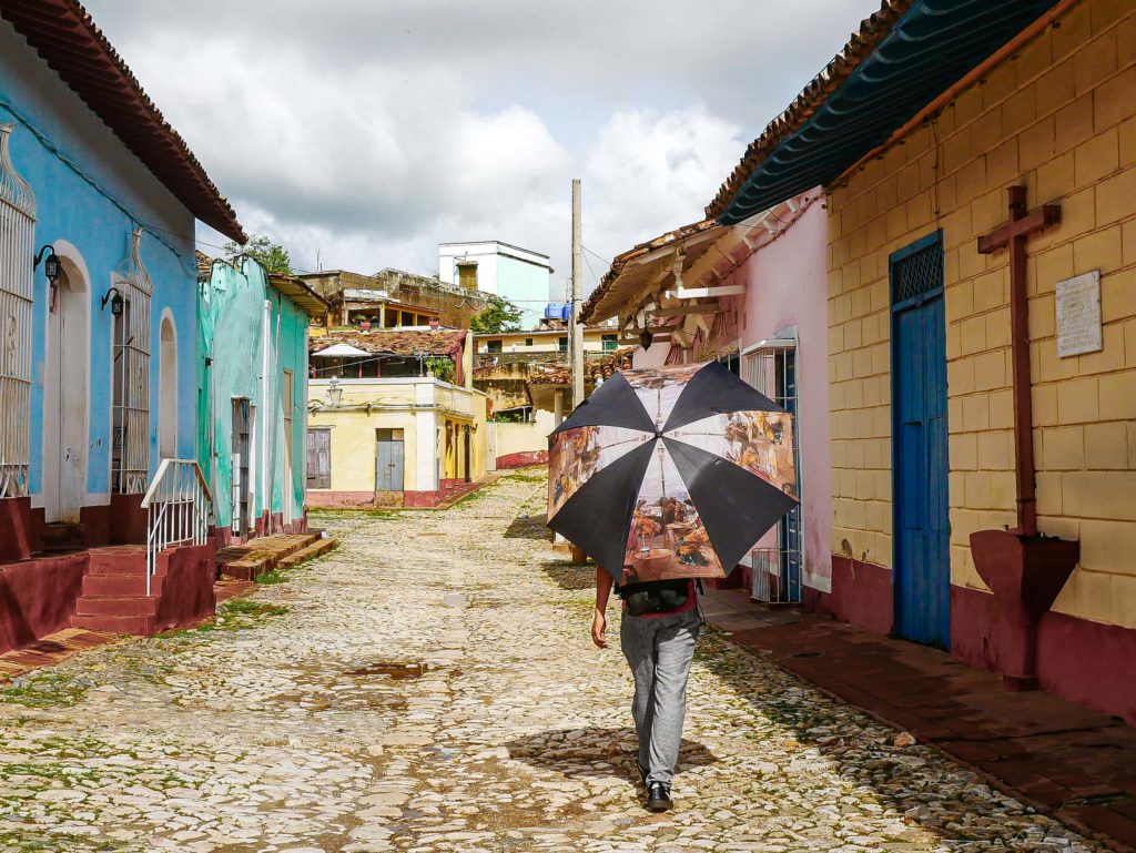 A lone walker avoiding the scorching sun with a decorated umbrella