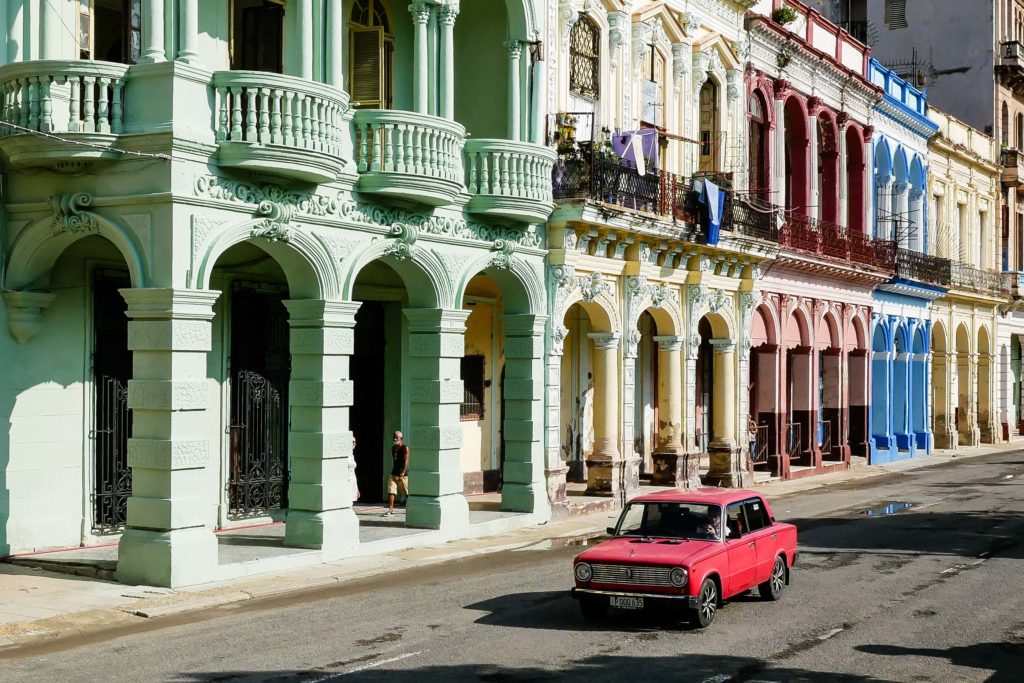 Pastel façades and a vintage red car in Havana