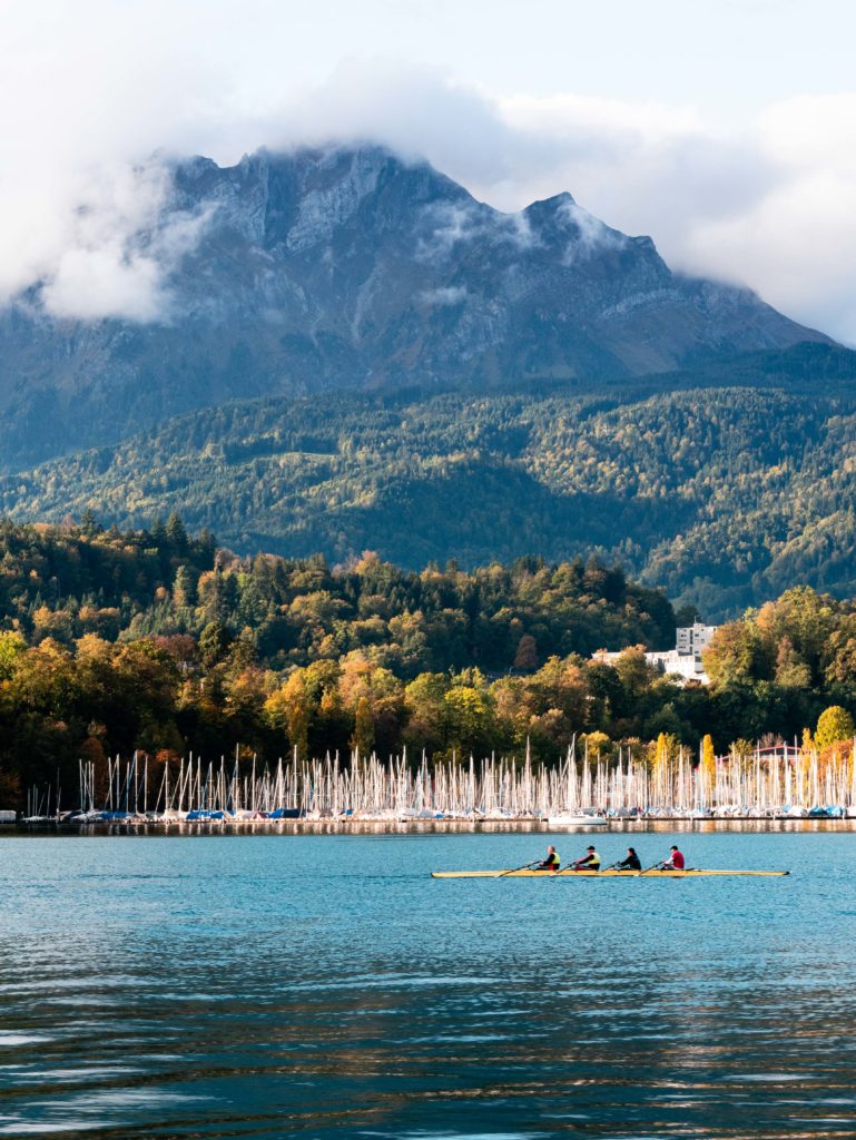 Morning light over Lake Lucerne, where rowers move quietly beneath the clouds of Mount Pilatus