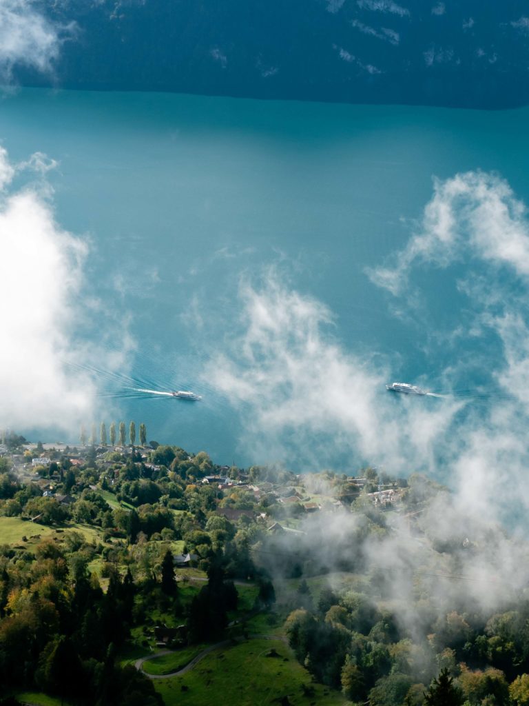 Through drifting clouds, boats trace silent paths across the turquoise waters of Lake Lucerne, Switzerland