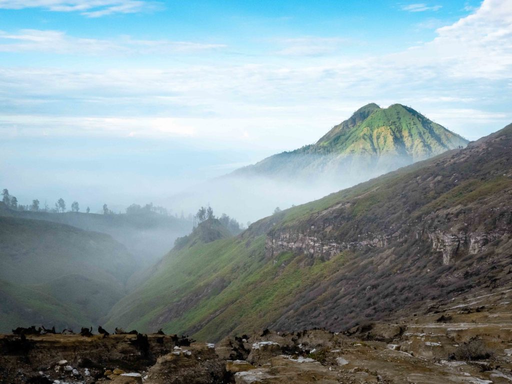 Misty mountain landscape around Mount Ijen crater at sunrise