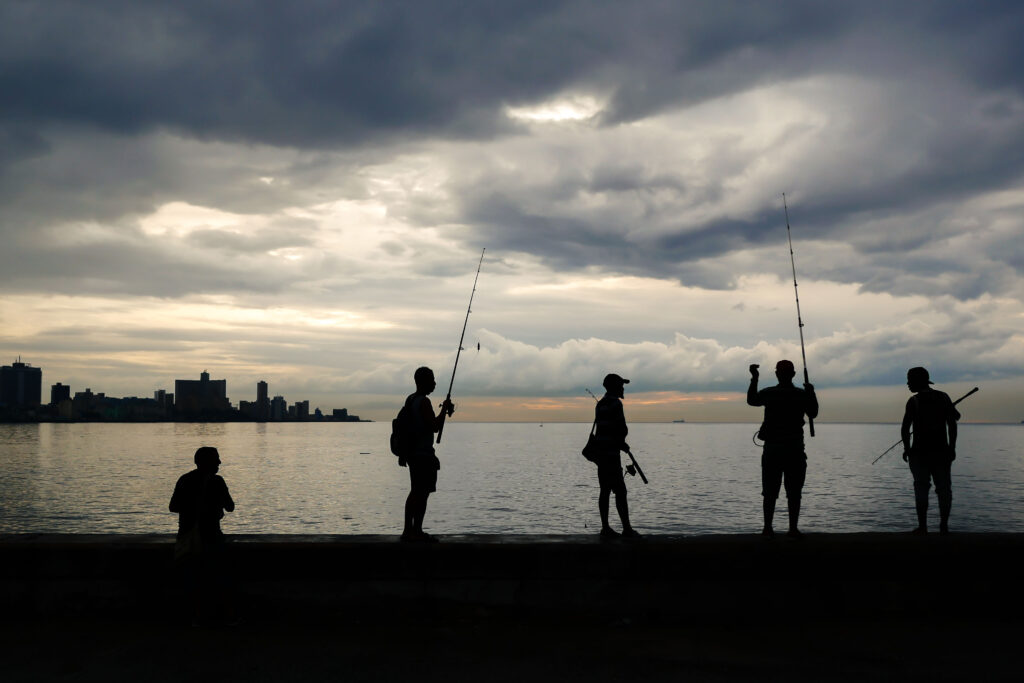 People watching the sea at sunset along Havana's Malecón