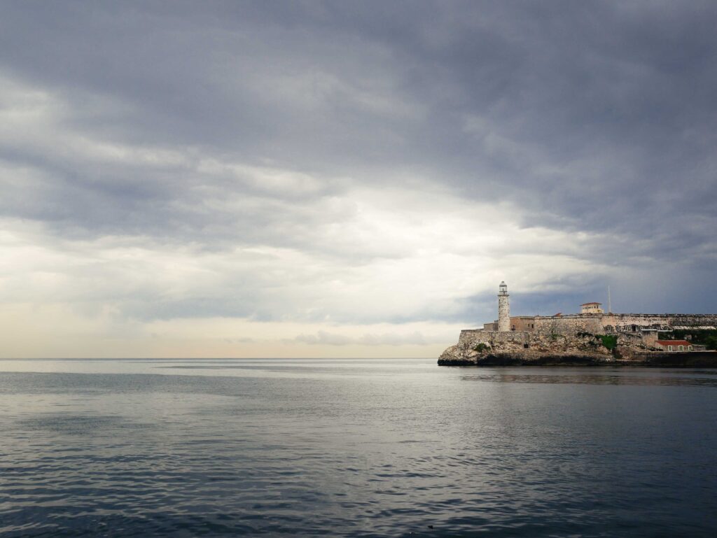 Calm sea and El Morro fortress under dramatic clouds in Havana