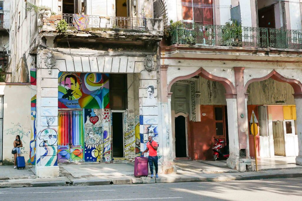 Historic Havana street with colorful murals and weathered facades