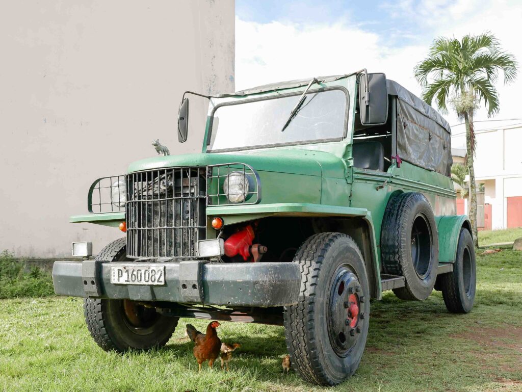 Russian green truck parked on a grassy field in rural Cuba